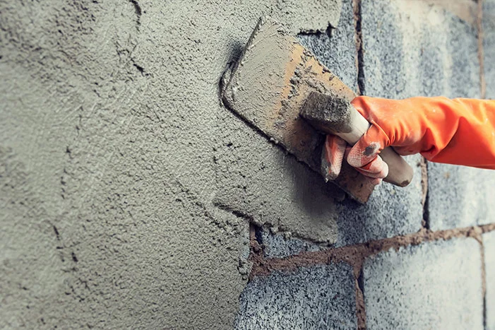 Person verputzt Wand